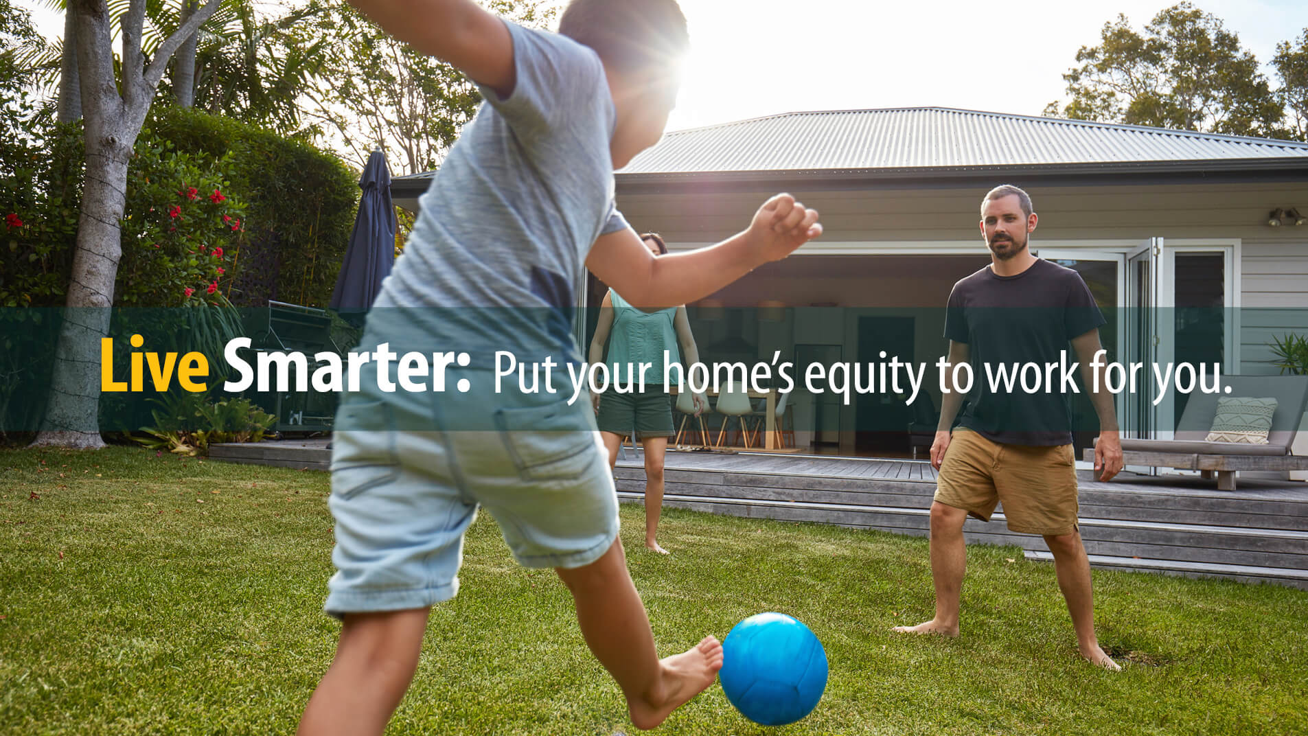 Dad, son play soccer in yard of home from which they will borrow against home equity